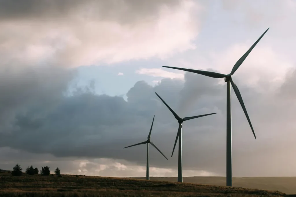 Wind turbines on a hillside under a cloudy sky